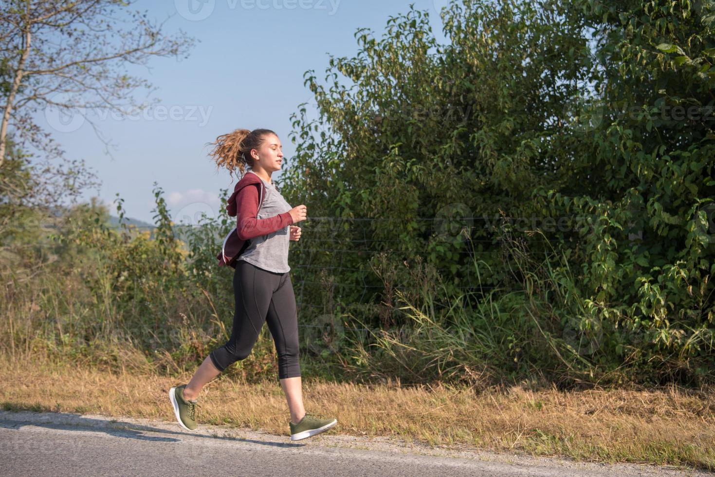 woman jogging along a country road photo