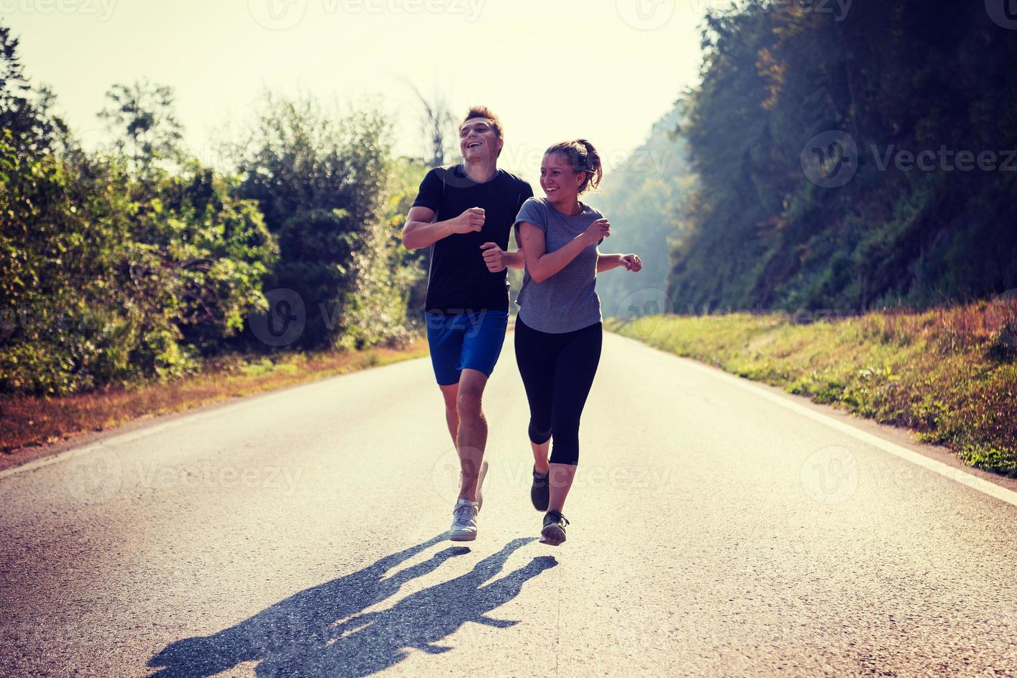 young couple jogging along a country road photo