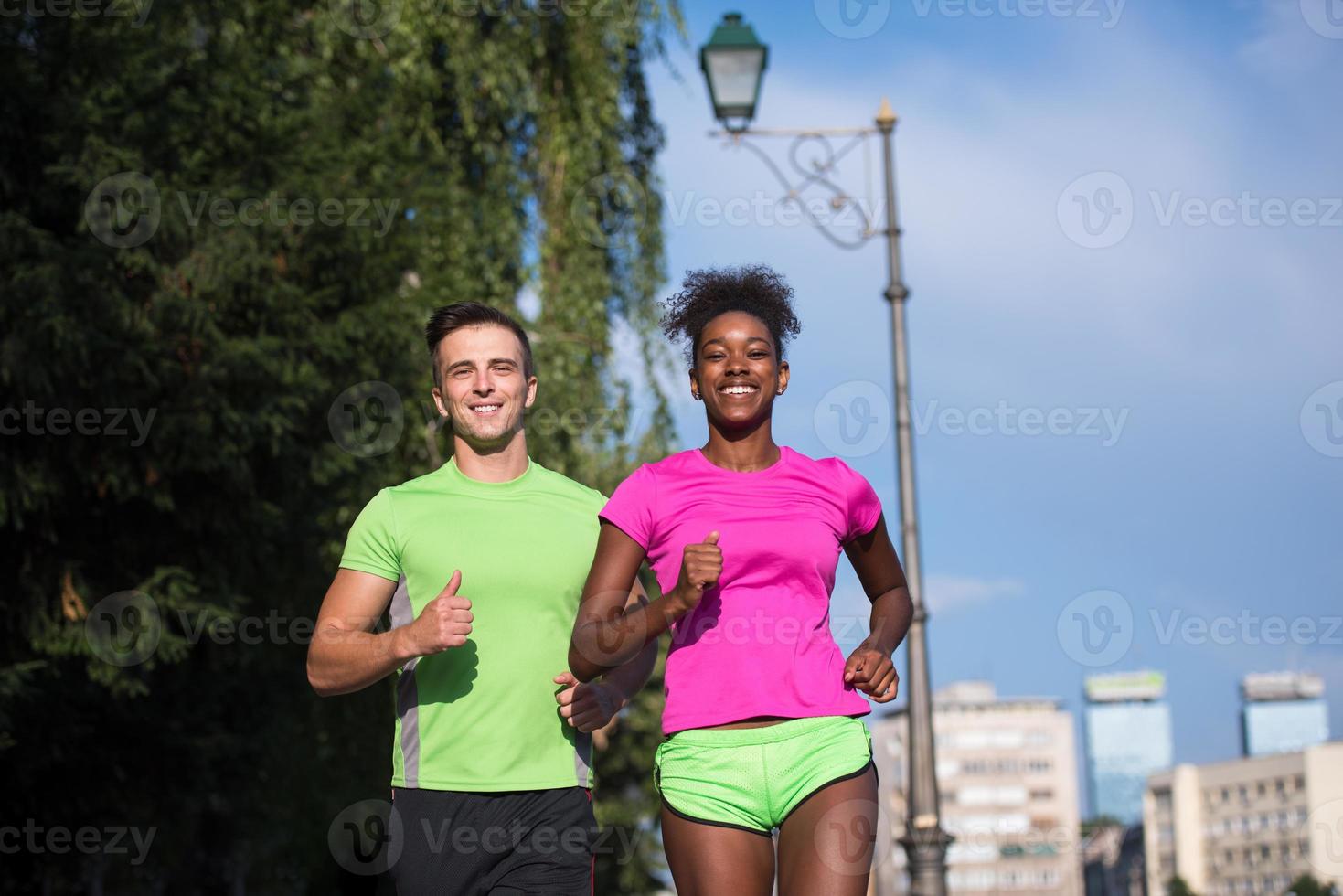 young smiling multiethnic couple jogging in the city photo