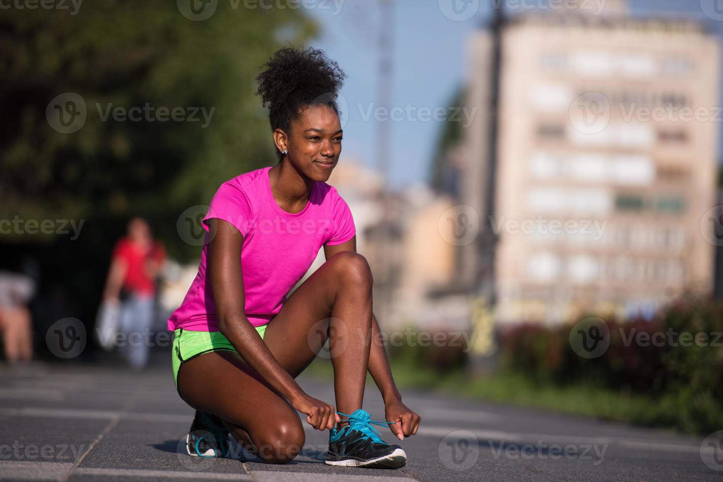 African american woman runner tightening shoe lace photo