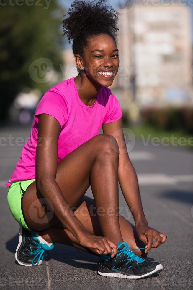 African american woman runner tightening shoe lace photo