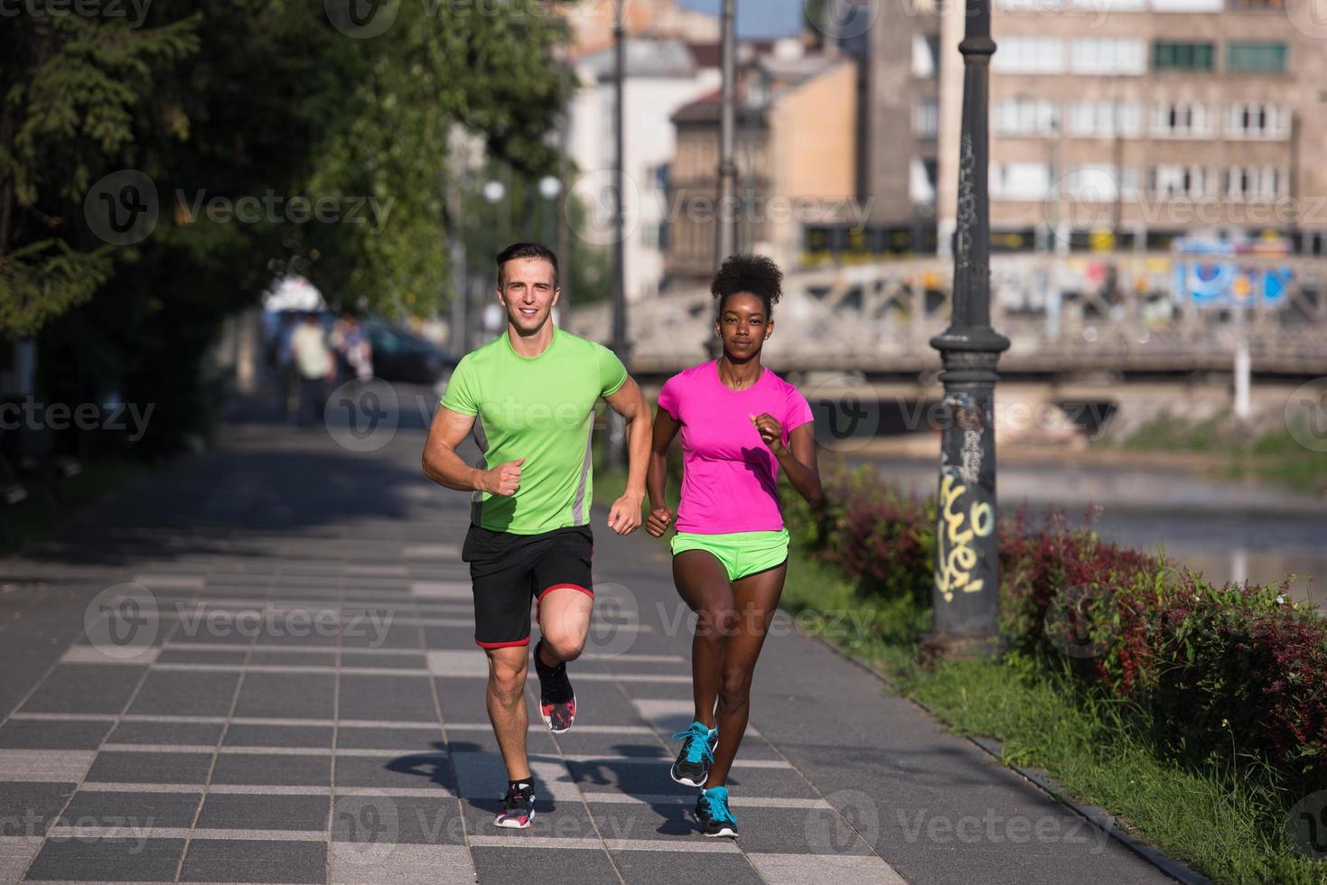 young smiling multiethnic couple jogging in the city photo