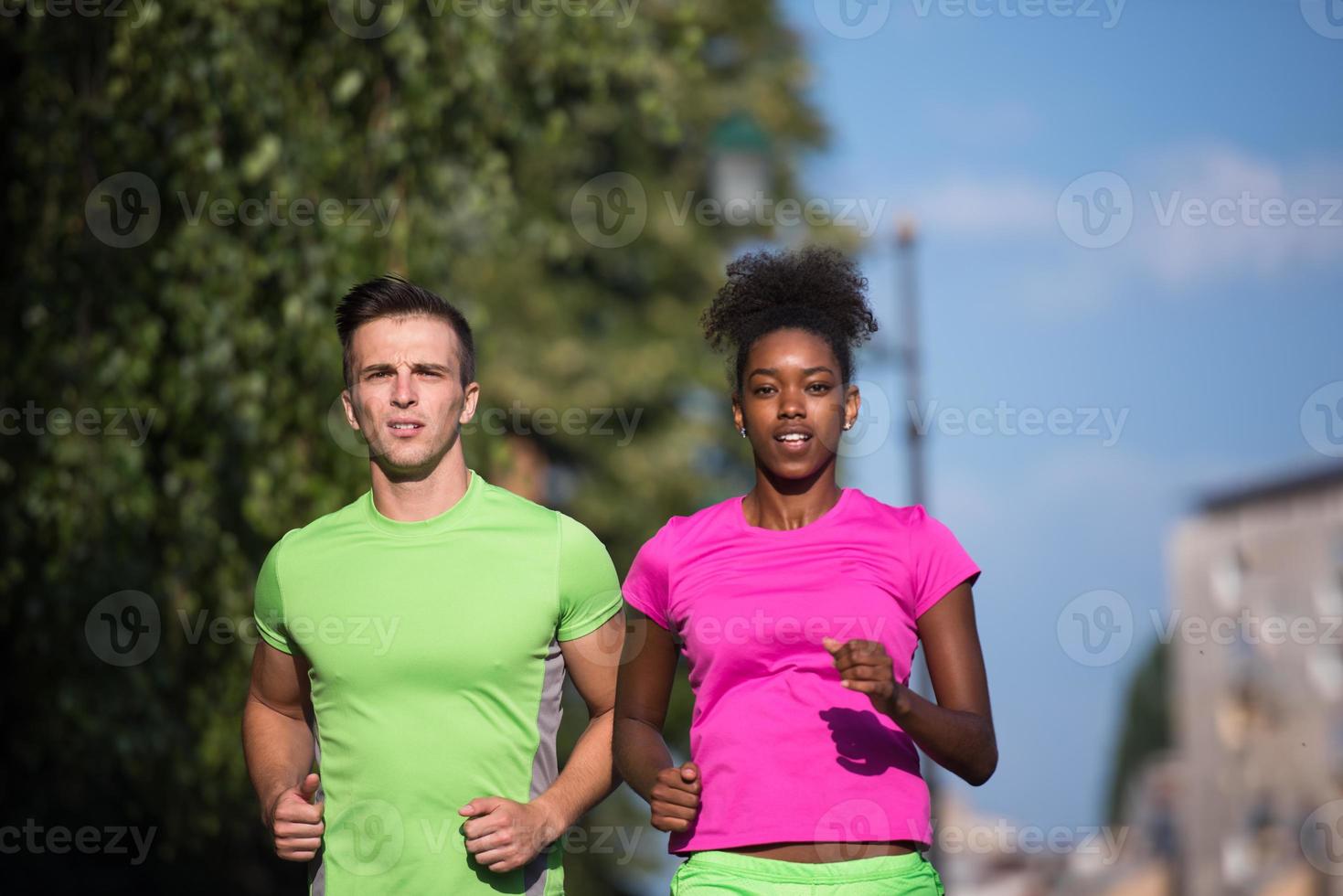 young smiling multiethnic couple jogging in the city photo