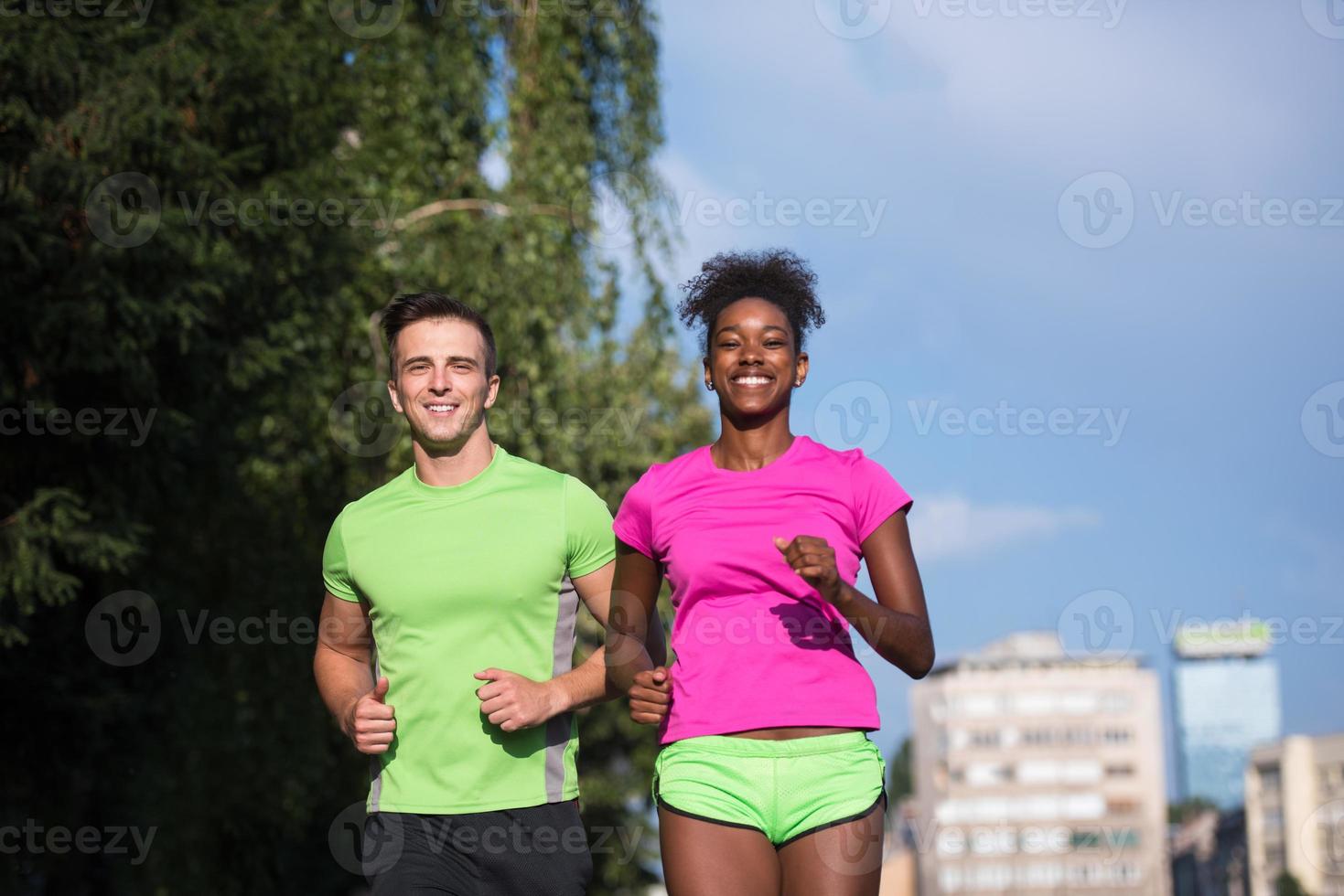 young smiling multiethnic couple jogging in the city photo