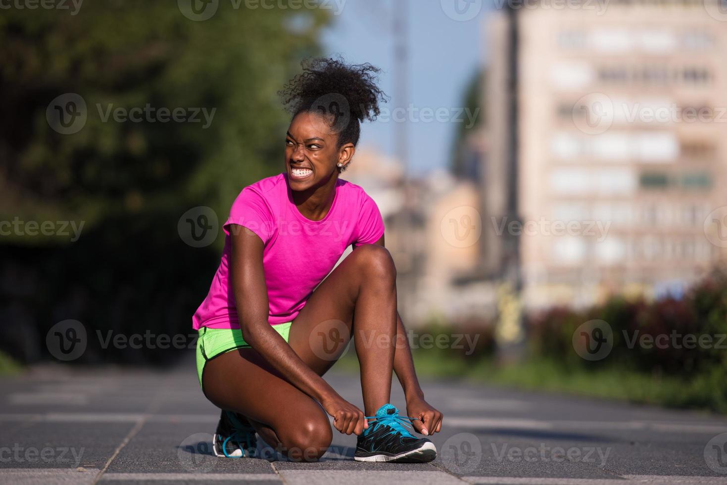 African american woman runner tightening shoe lace photo