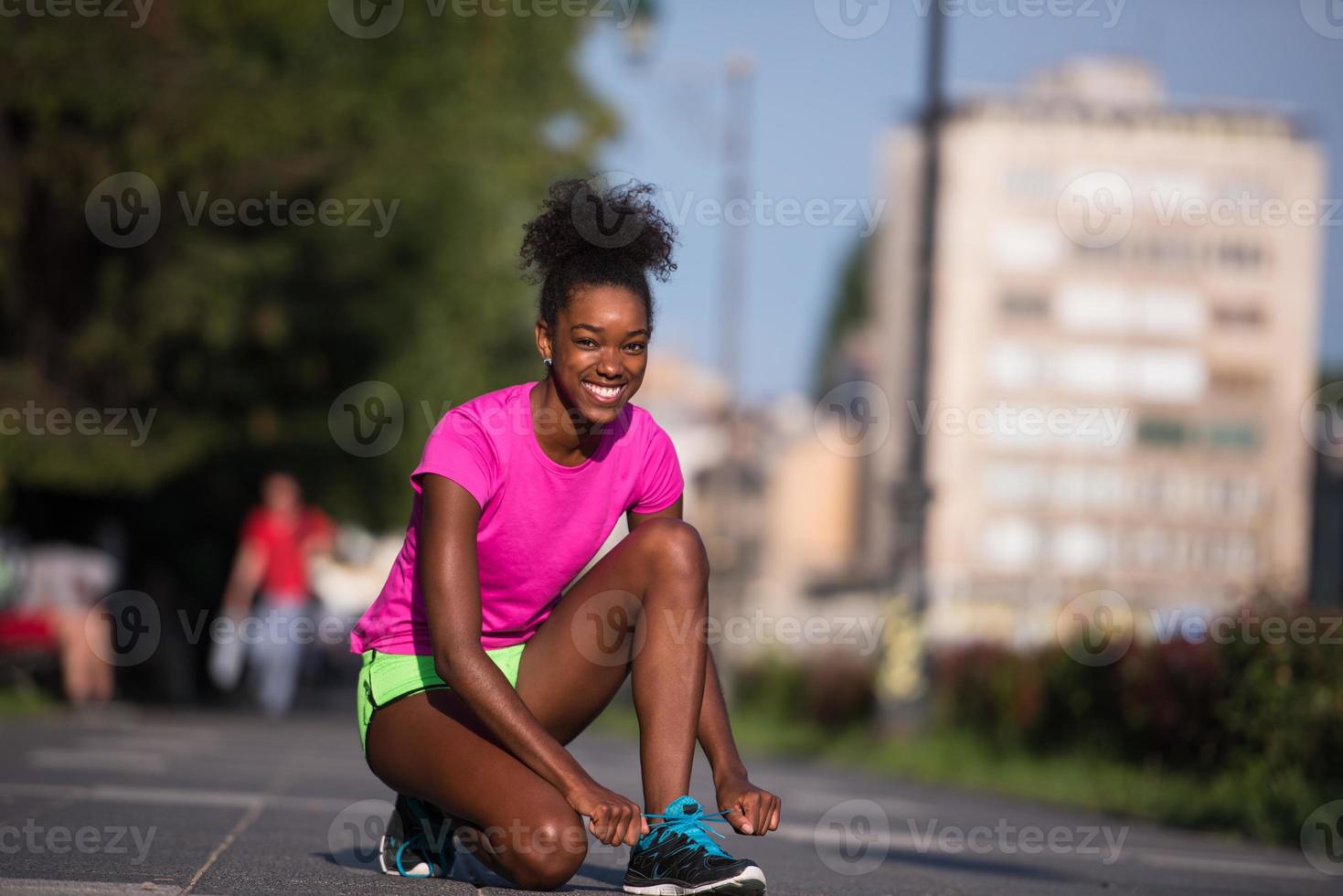 African american woman runner tightening shoe lace photo