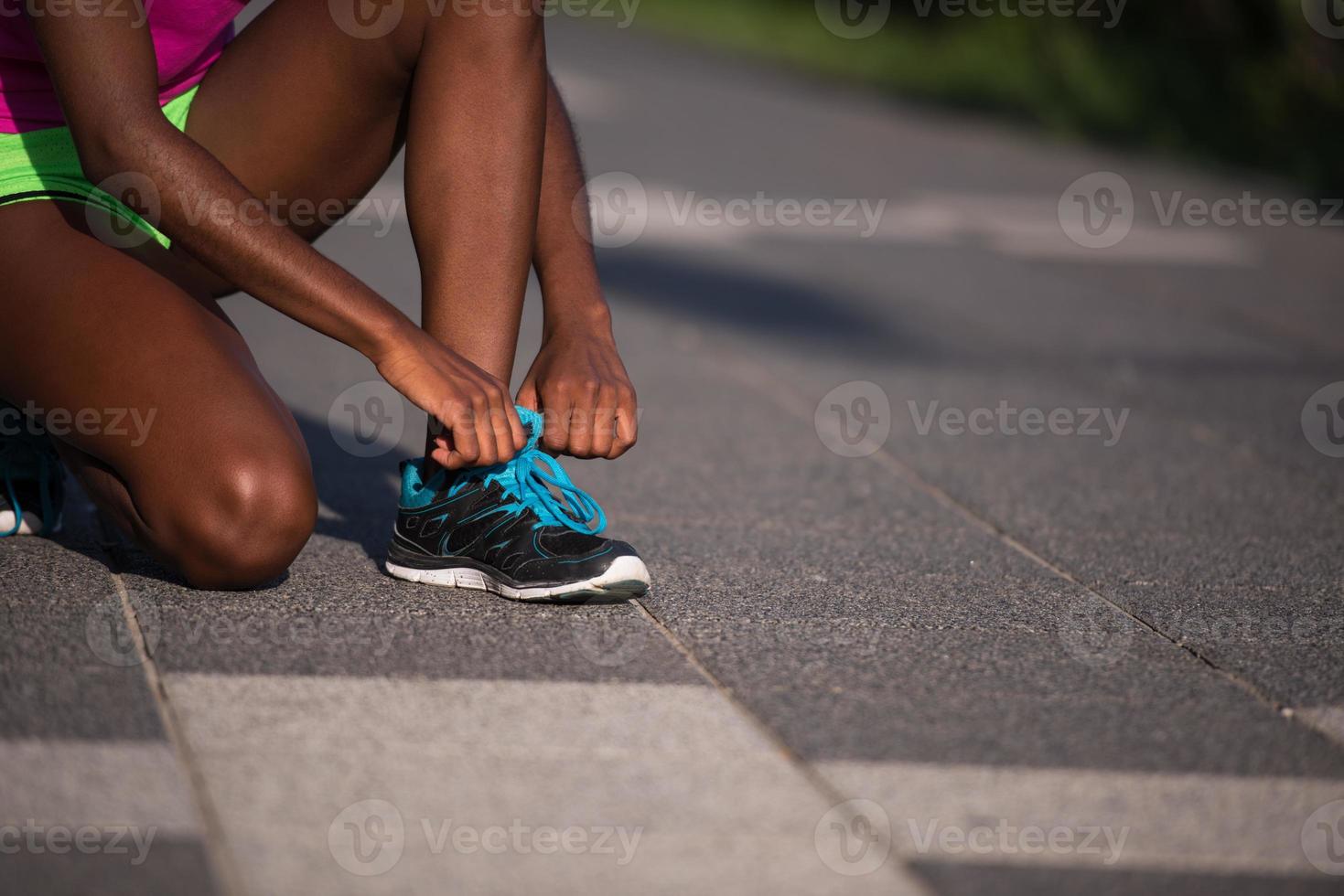 African american woman runner tightening shoe lace photo