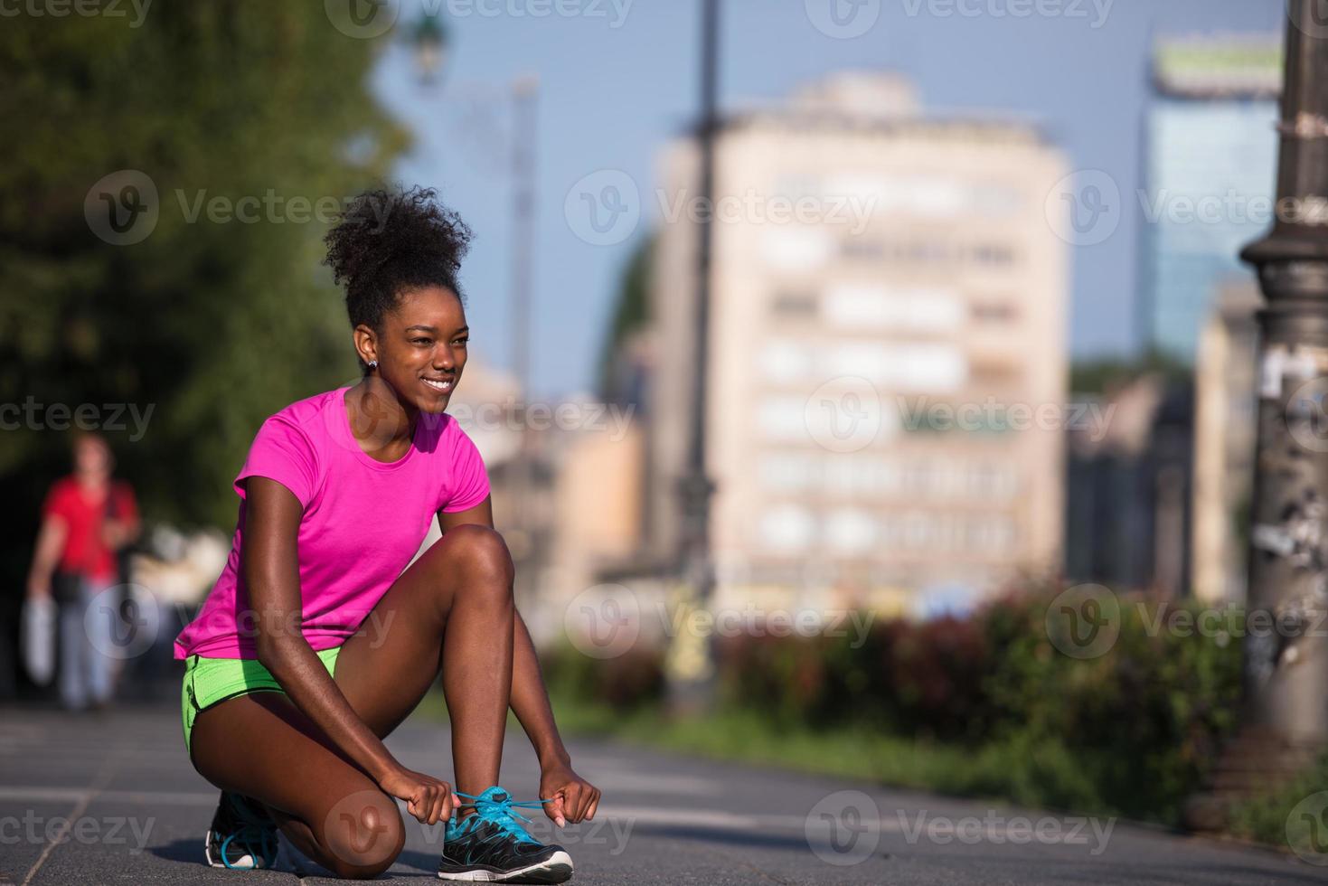 African american woman runner tightening shoe lace photo