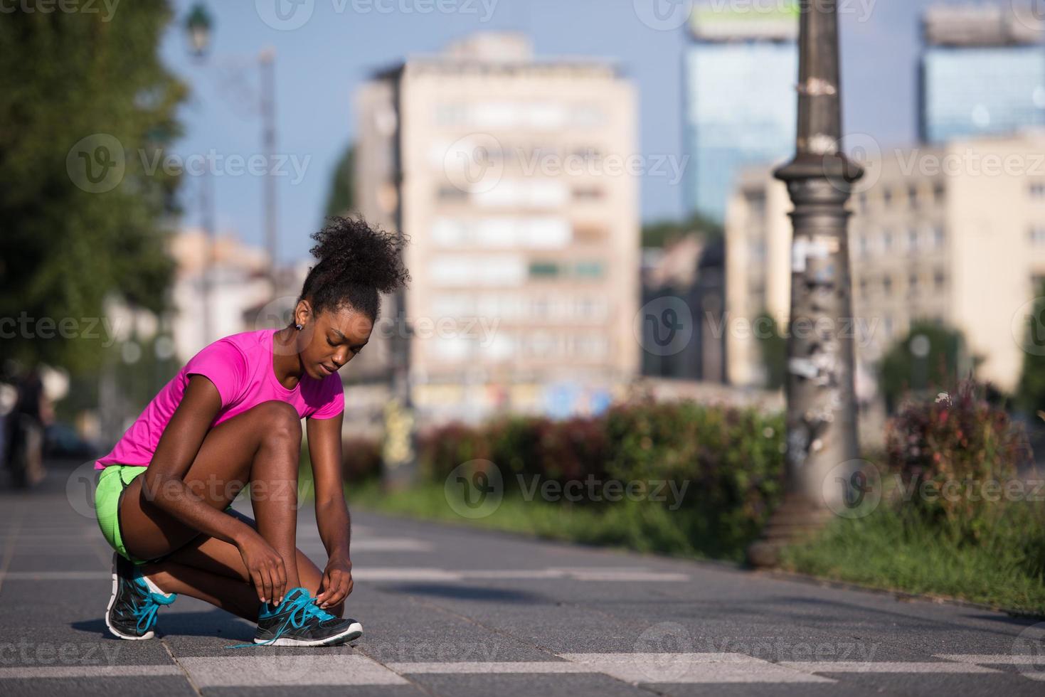 African american woman runner tightening shoe lace photo