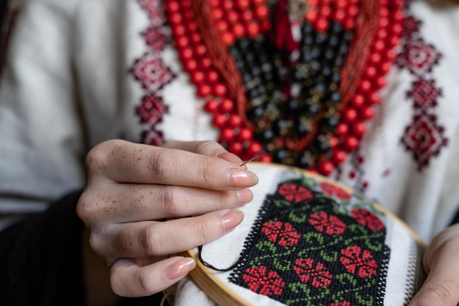 A girl embroiders a traditional Ukrainian vyshyvanka pattern photo