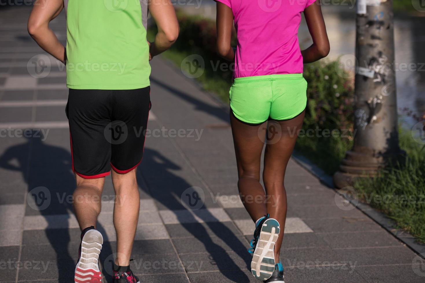 young smiling multiethnic couple jogging in the city photo