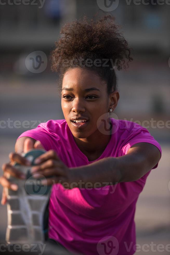 mujer afroamericana haciendo calentamiento y estiramiento foto