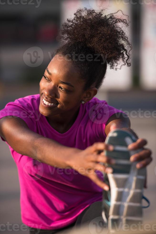 mujer afroamericana haciendo calentamiento y estiramiento foto