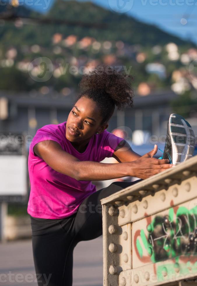 mujer afroamericana haciendo calentamiento y estiramiento foto