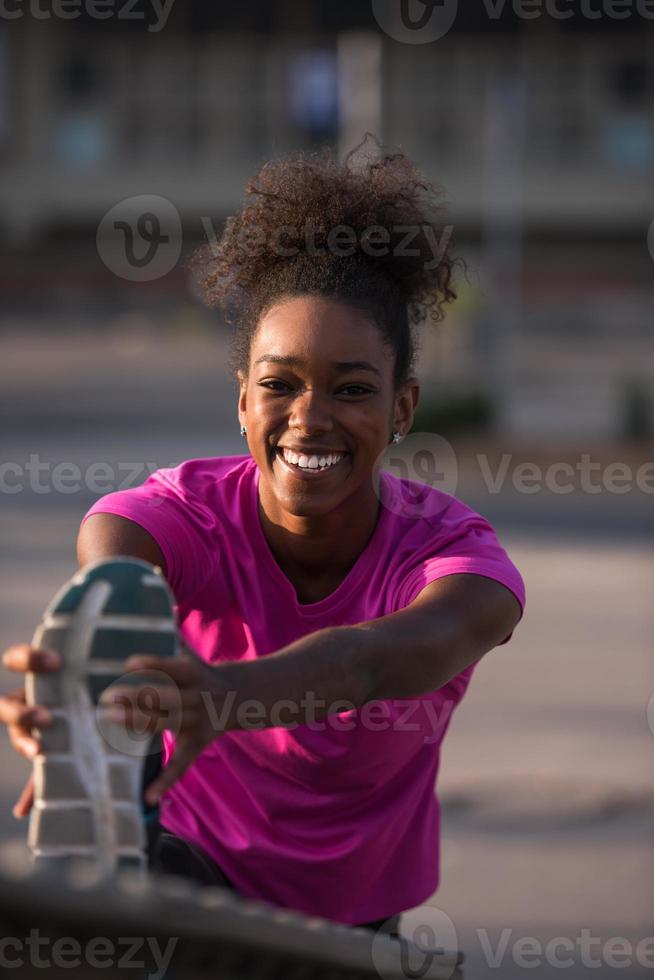 mujer afroamericana haciendo calentamiento y estiramiento foto