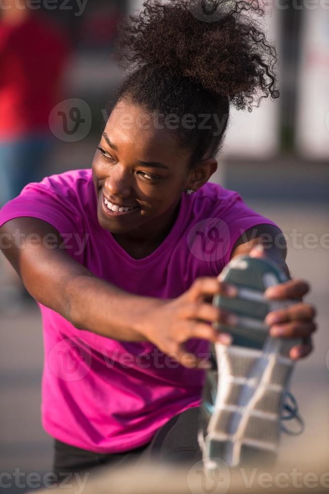 mujer afroamericana haciendo calentamiento y estiramiento foto