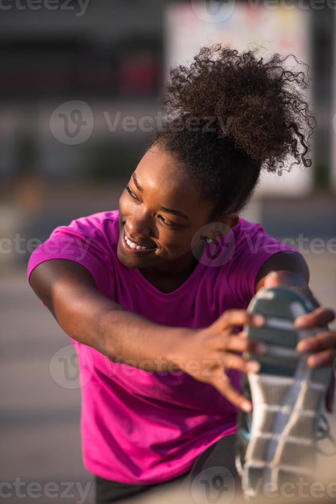mujer afroamericana haciendo calentamiento y estiramiento foto