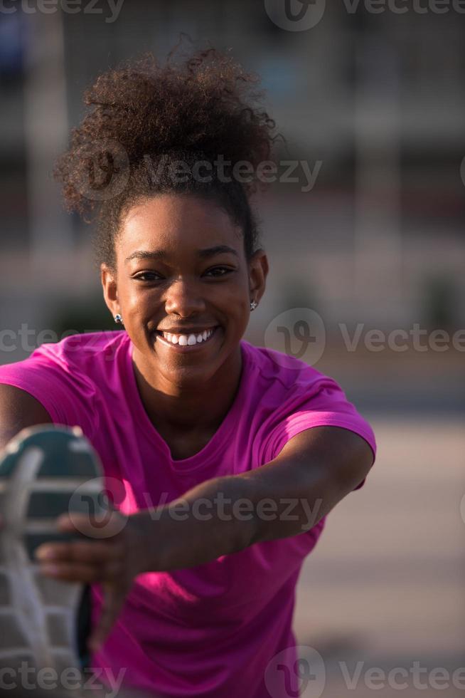 mujer afroamericana haciendo calentamiento y estiramiento foto