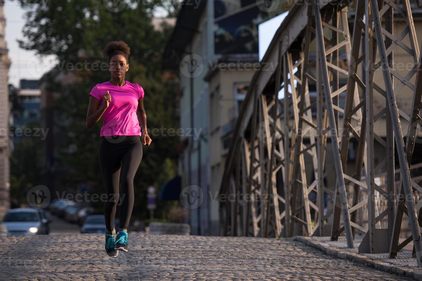 african american woman running across the bridge photo