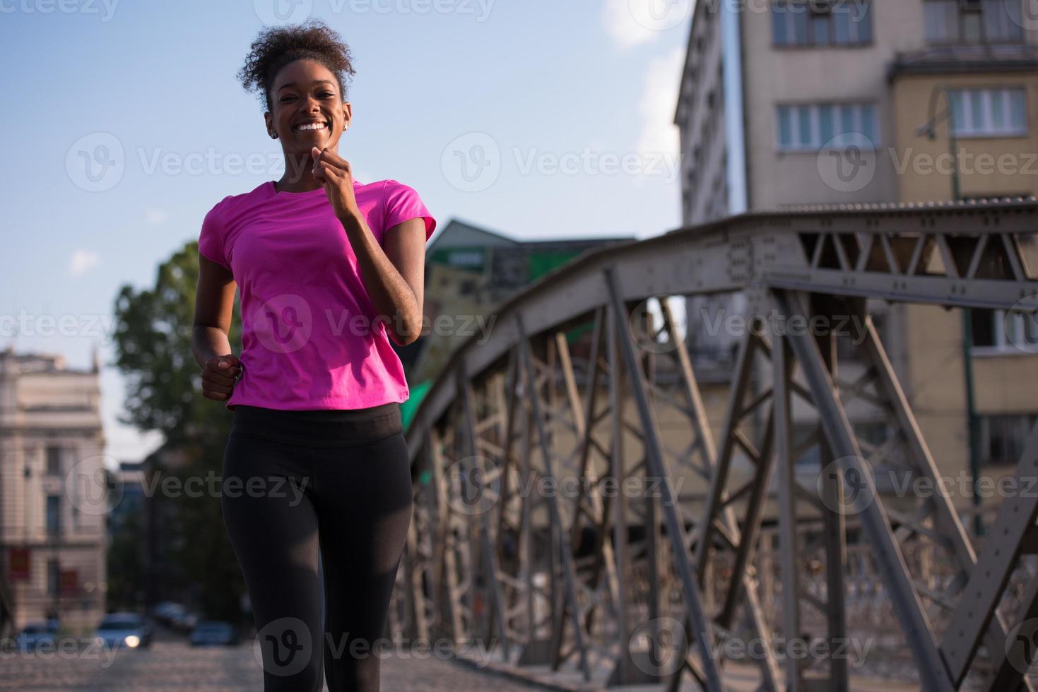 african american woman running across the bridge photo