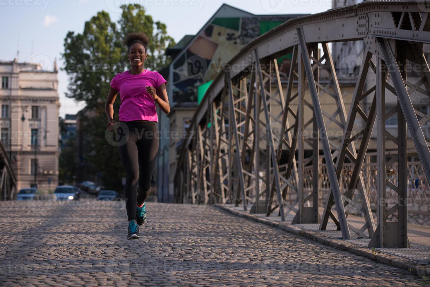 african american woman running across the bridge photo