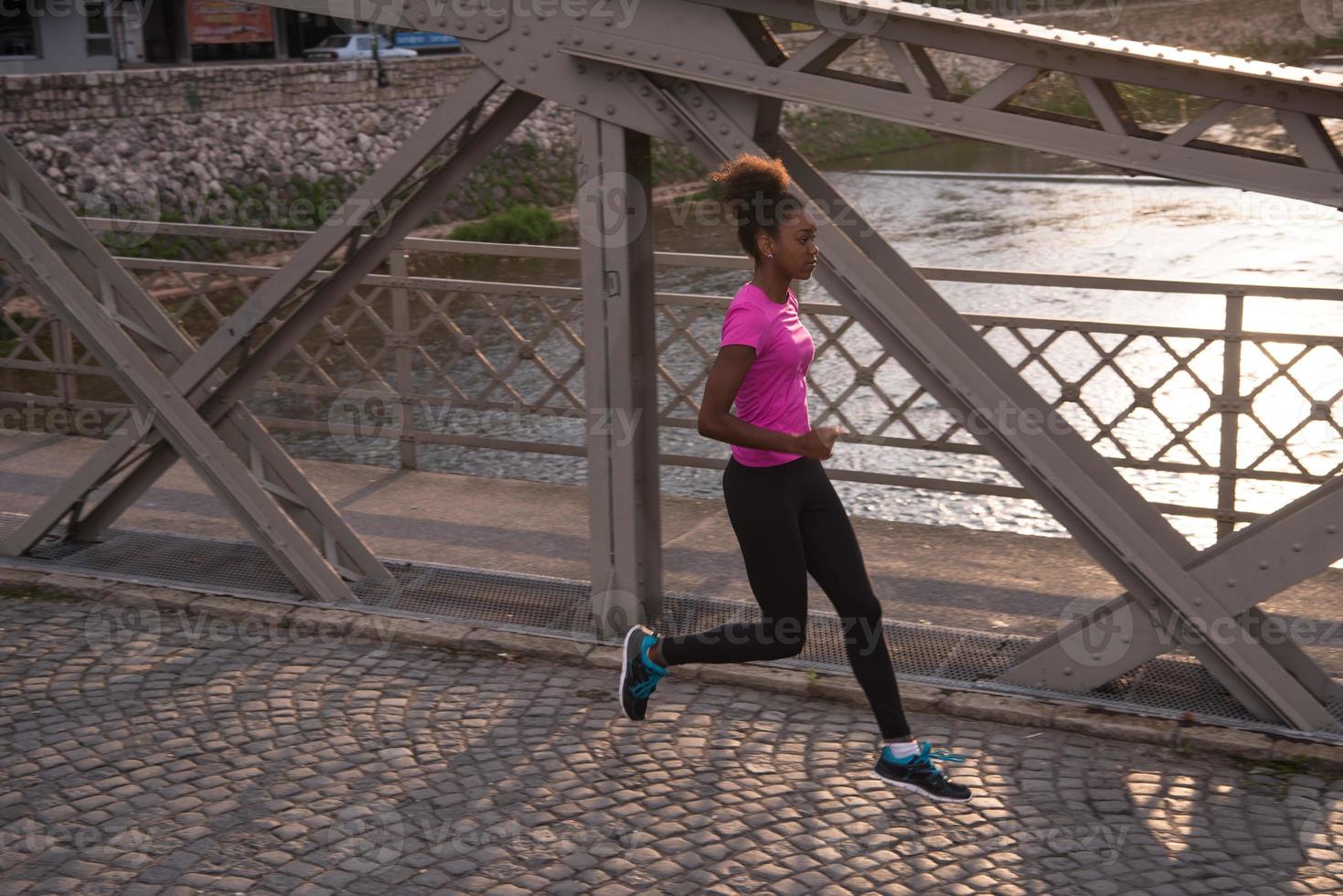 african american woman running across the bridge photo