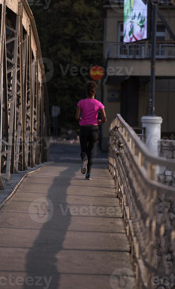 african american woman running across the bridge photo