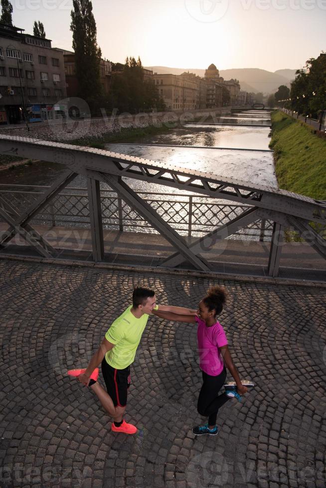 jogging couple warming up and stretching in the city photo