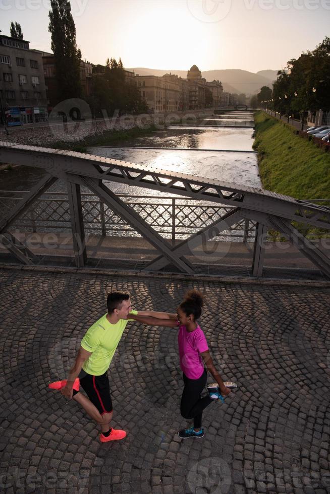 jogging couple warming up and stretching in the city photo