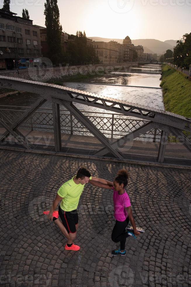 jogging couple warming up and stretching in the city photo