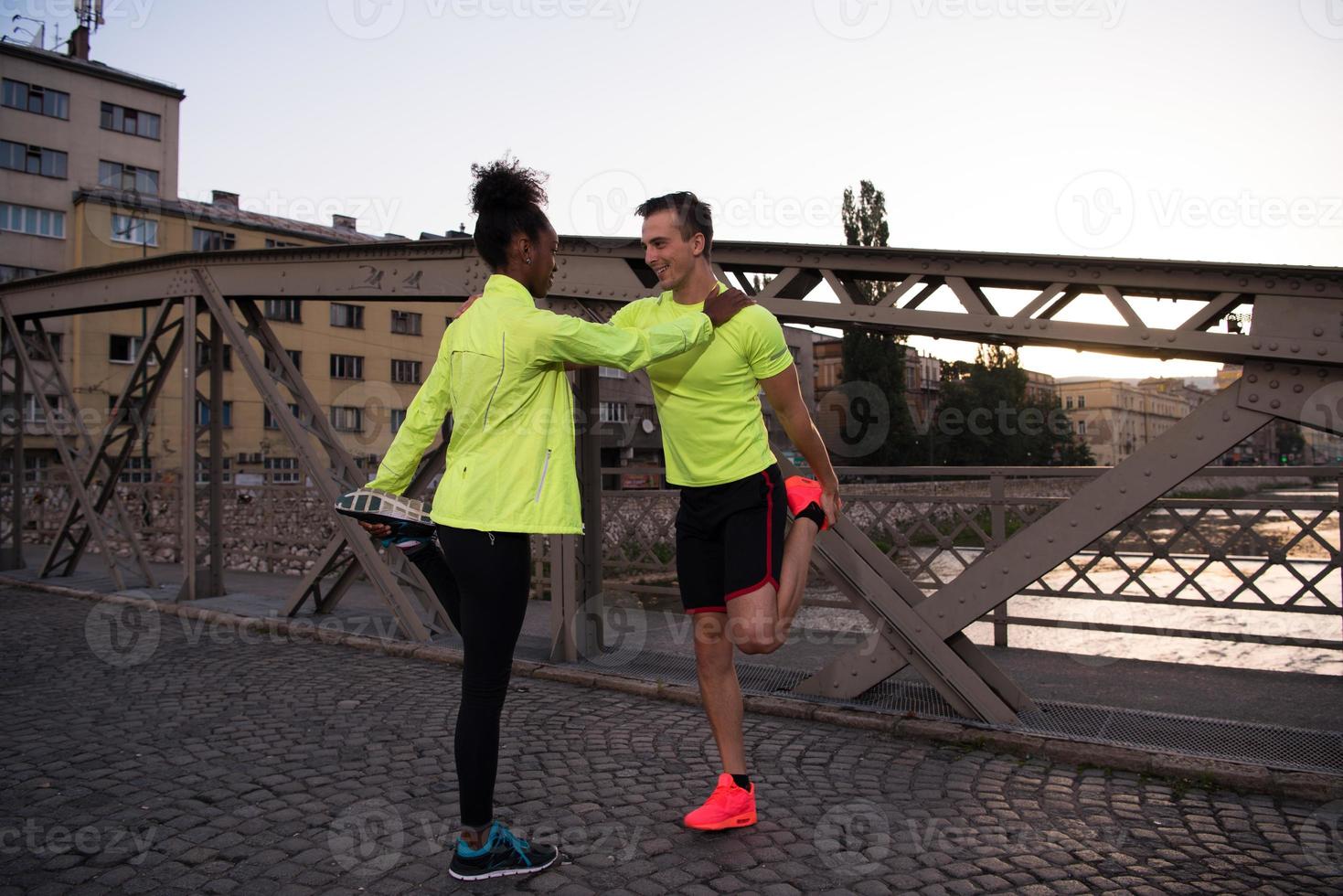 jogging couple warming up and stretching in the city photo