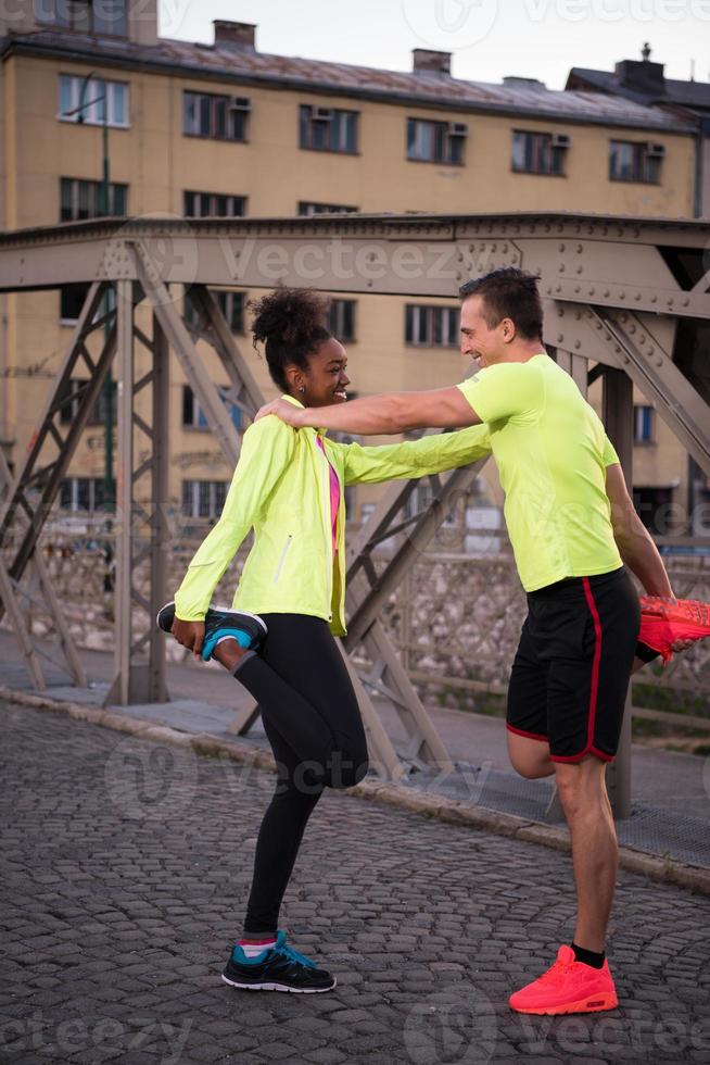 jogging couple warming up and stretching in the city photo