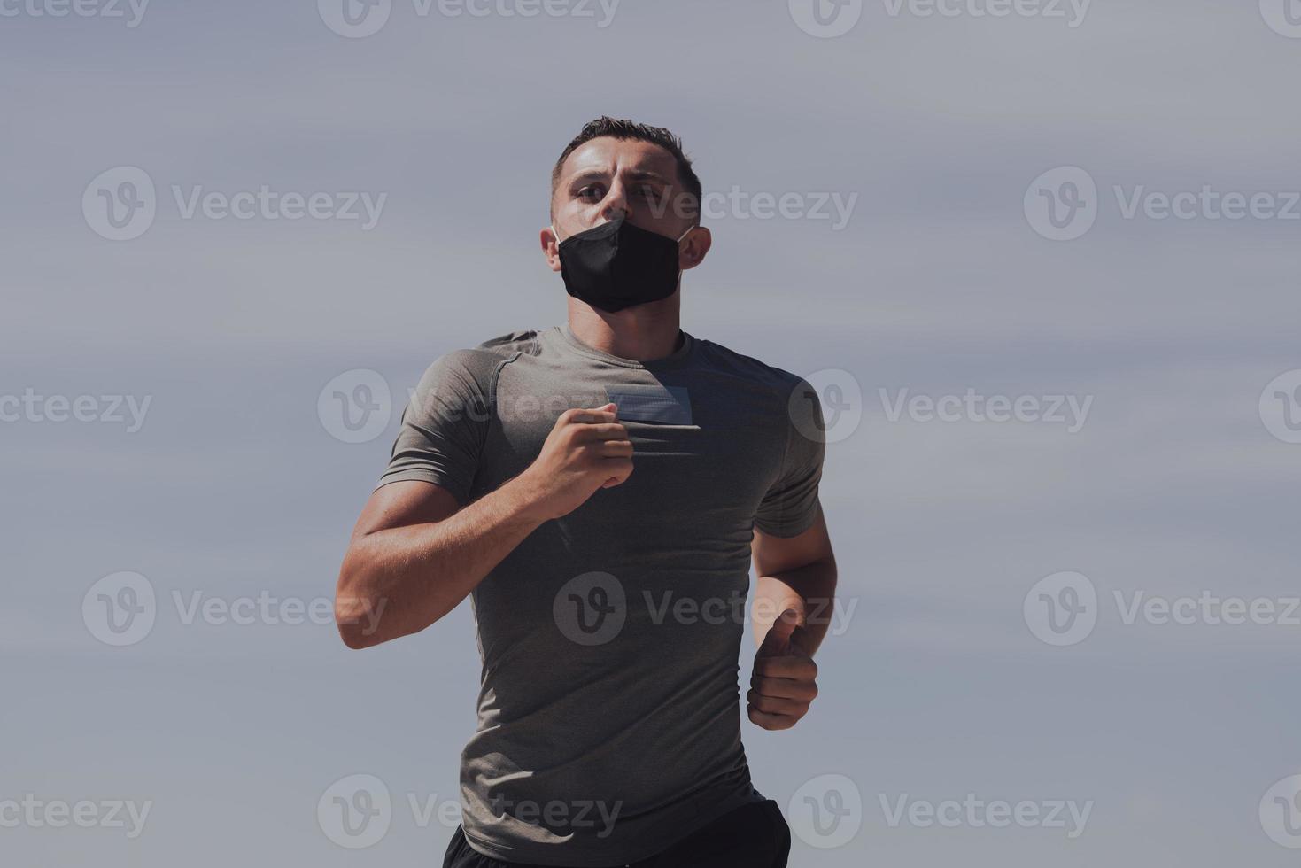 Young man and woman in protective masks running and doing exercises outdoors in the morning. Sport, Active life Jogging during quarantine. Covid-19 new normal. High quality photo. Selective focus. photo