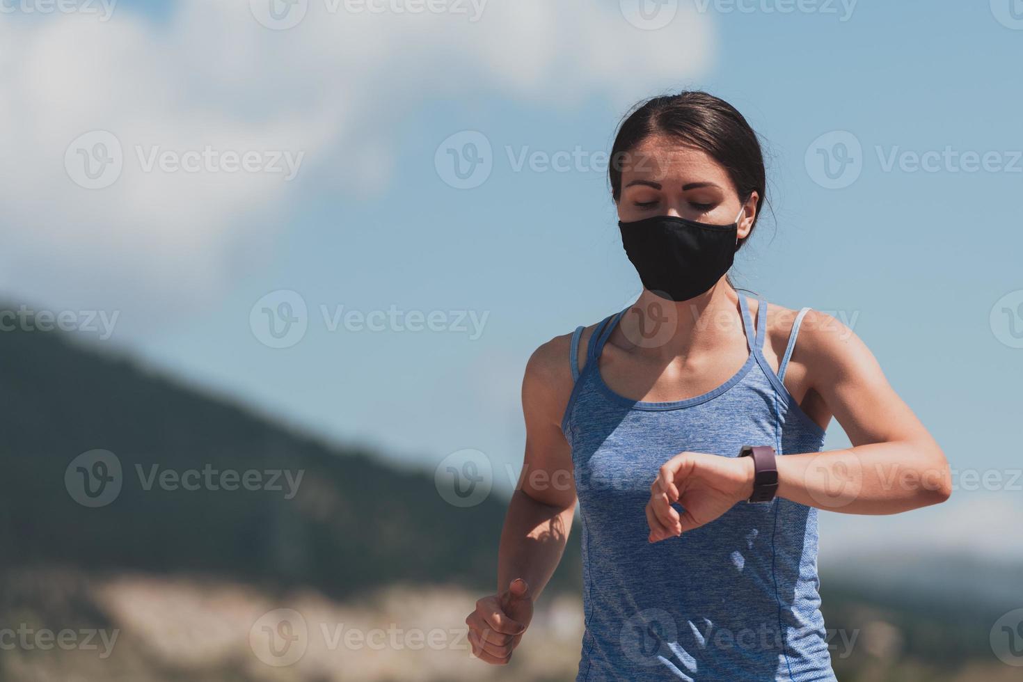 determinada mujer fitness con ropa corta y mascarilla protectora roja corriendo al aire libre en la ciudad durante el brote de coronavirus. covid 19 y actividad física de jogging, deporte y fitness. foto