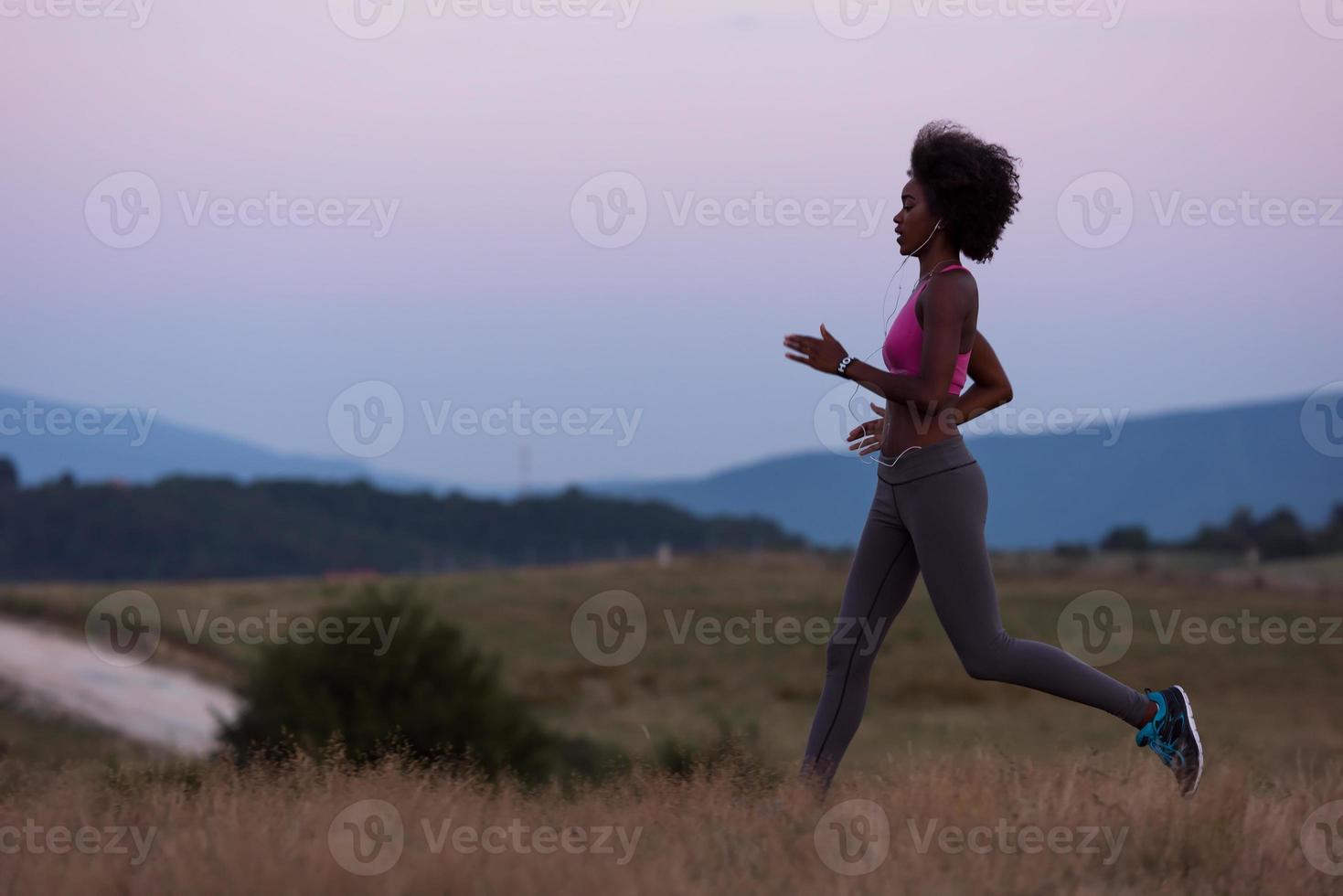 Young African american woman jogging in nature photo