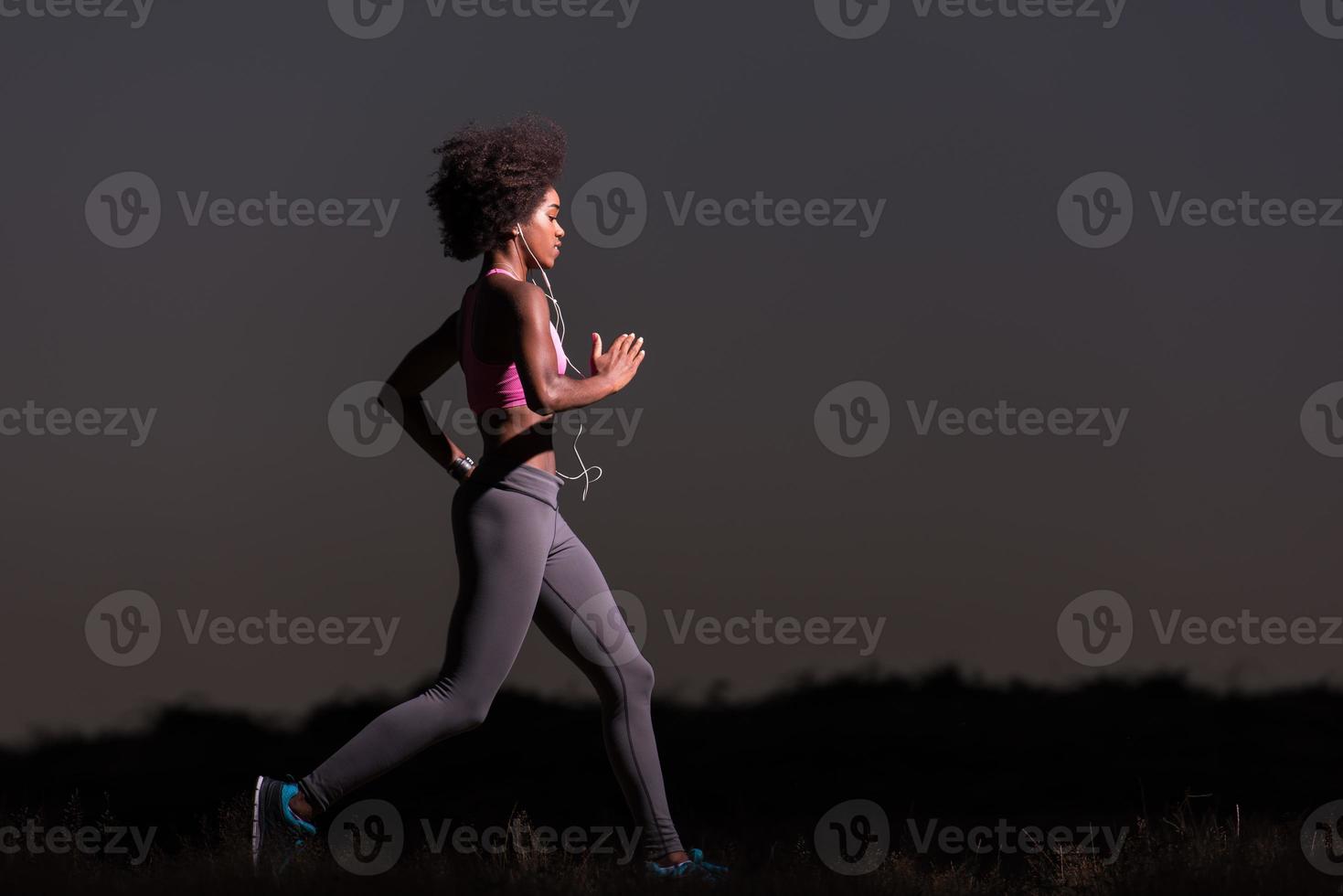 Young African american woman jogging in nature photo