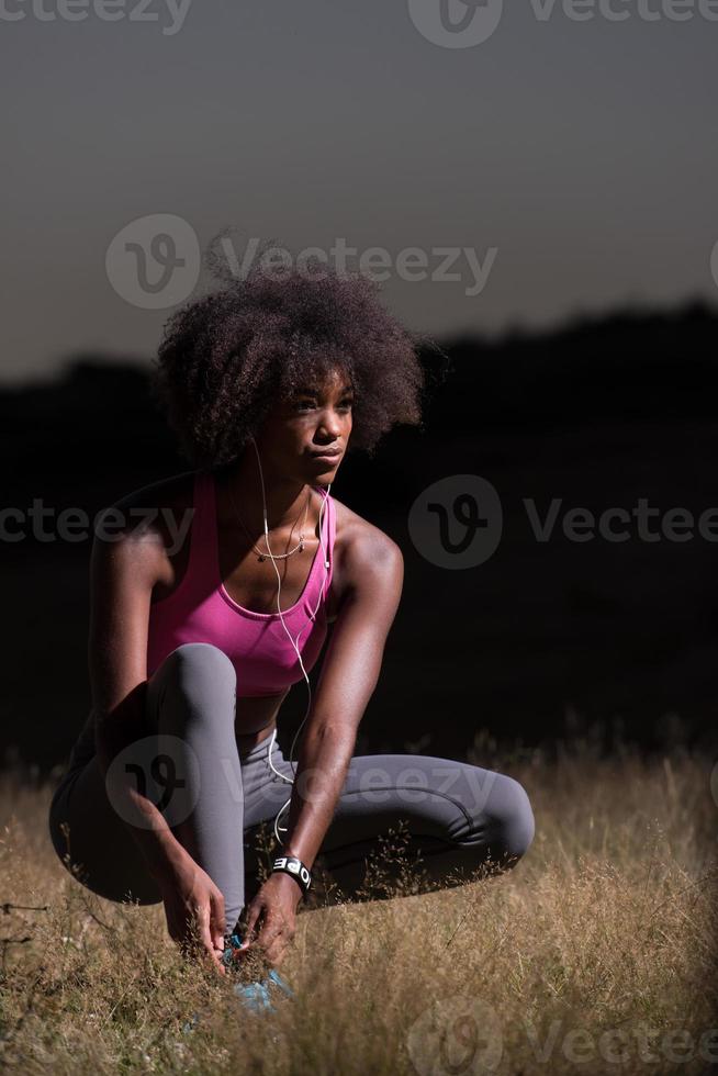 black woman runner tightening shoe lace photo