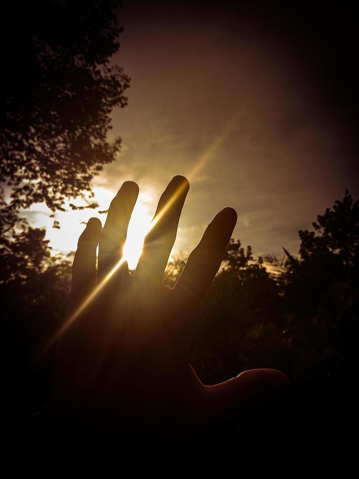 beautiful sunset view behind hand photo