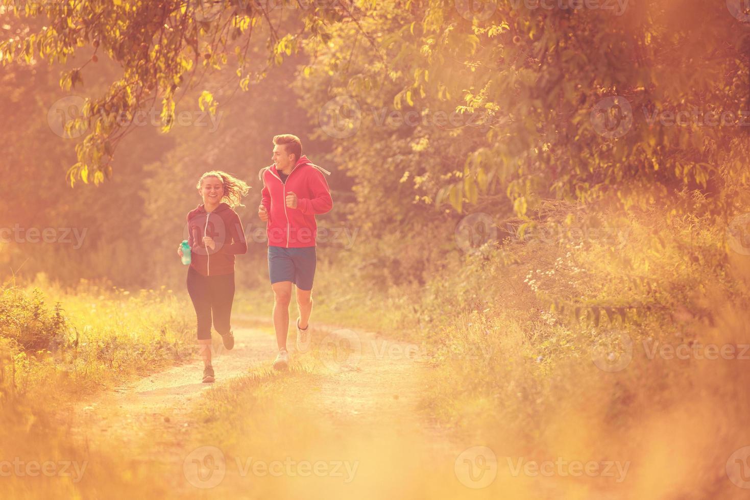 young couple jogging along a country road photo