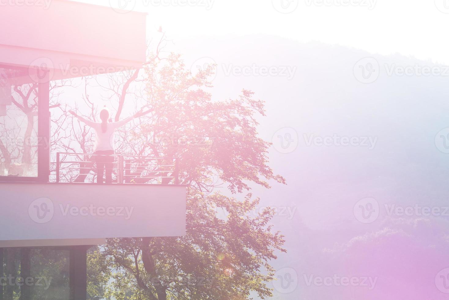 mujer estirando los brazos en el balcón foto