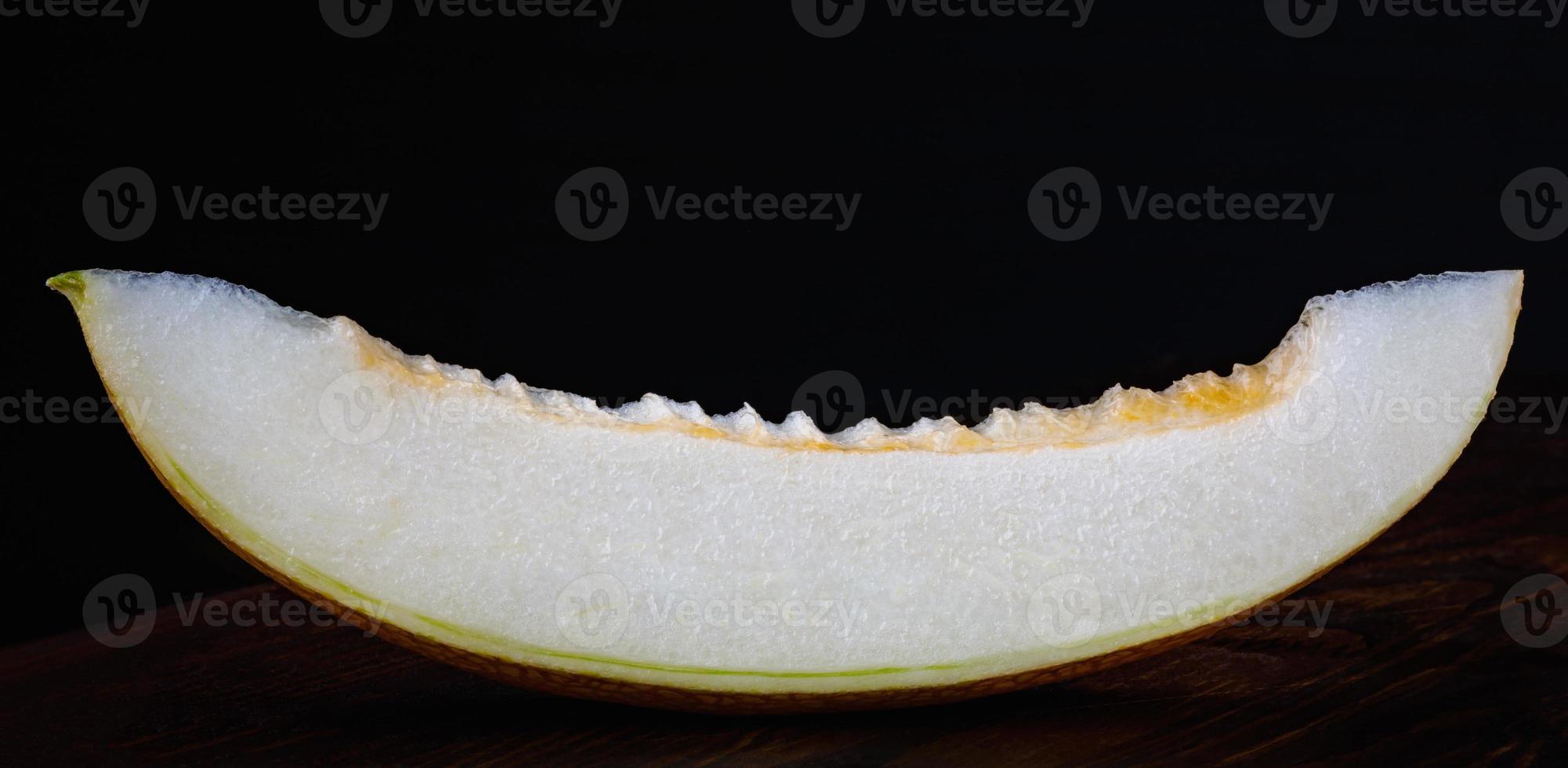 A piece of ripe melon on a black background. photo