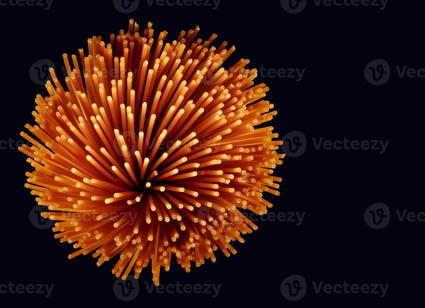 A bunch of tomato pasta on a dark background. Colored spaghetti. Red tomato pasta. photo