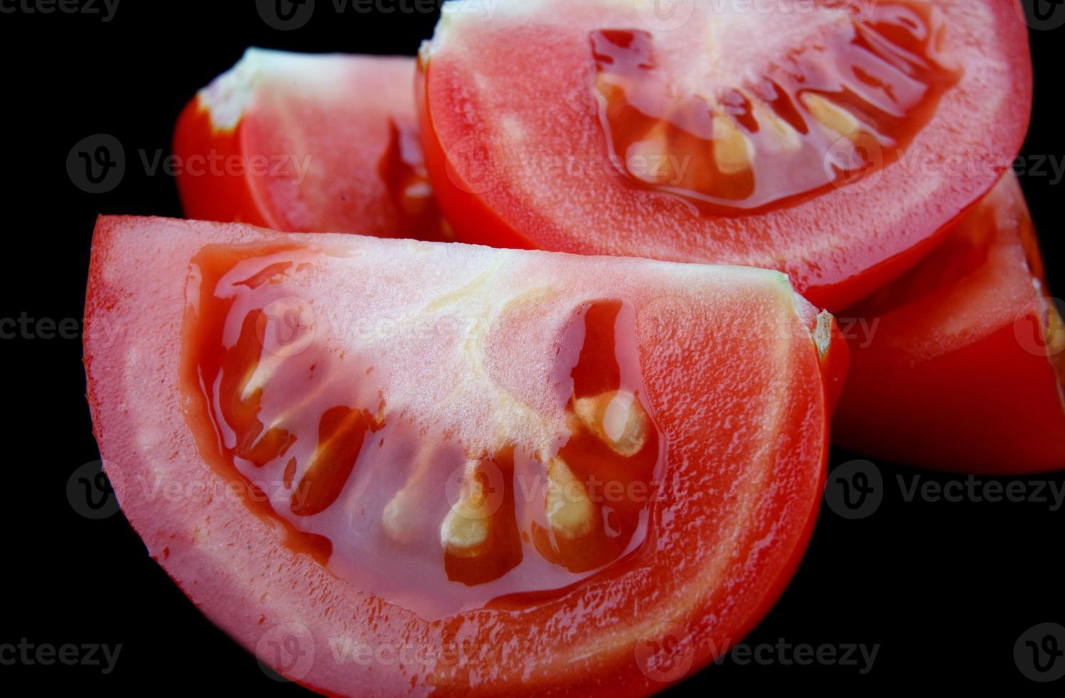 Pieces of cut tomato on a black background. 10673438 Stock Photo at