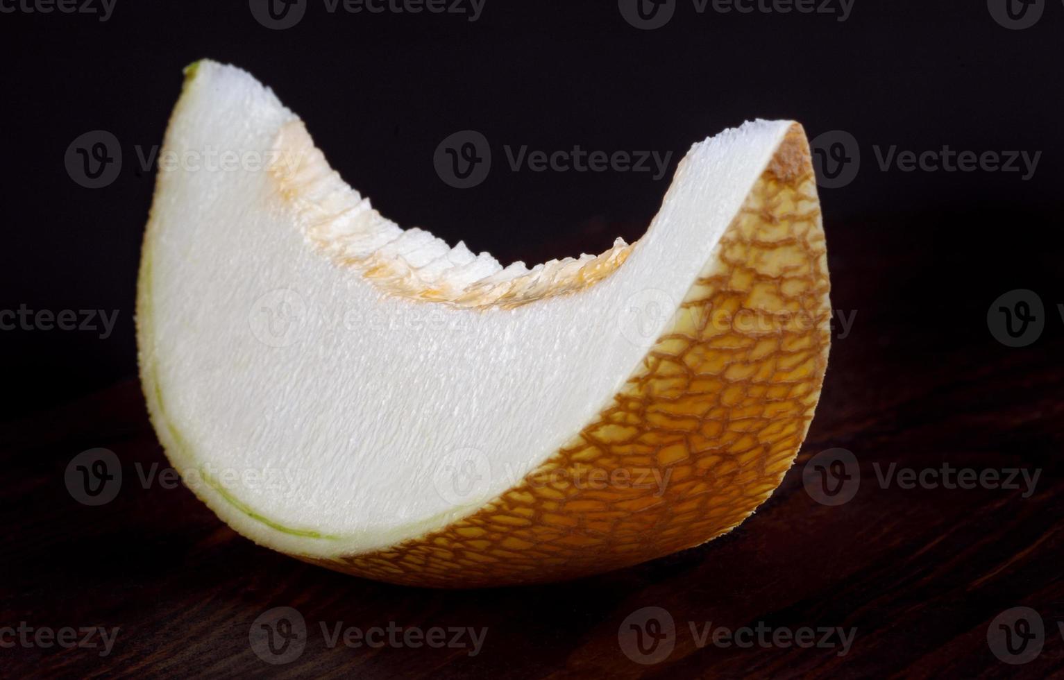 A beautiful piece of ripe melon on a wooden table. photo