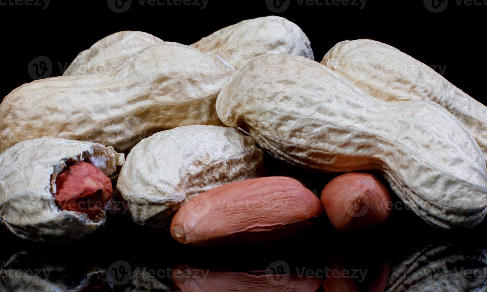 Peanuts in the shell and without it on a black background. photo