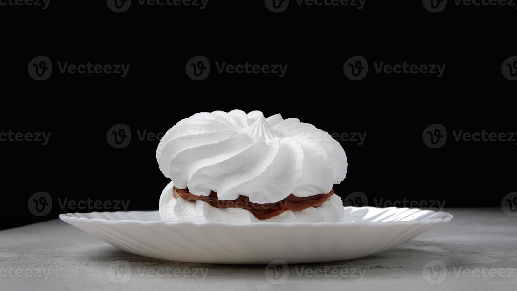 Two snow-white meringues on a white plate. Beautiful white cake. photo