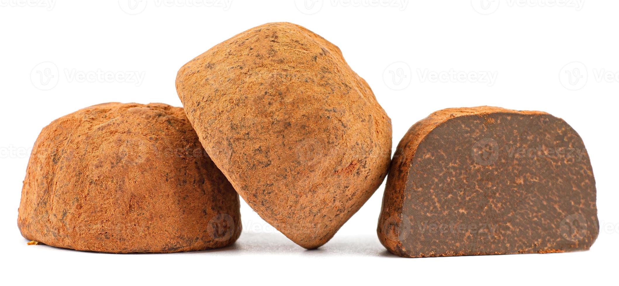 Chocolate truffles are whole and half are isolated on a white background. photo
