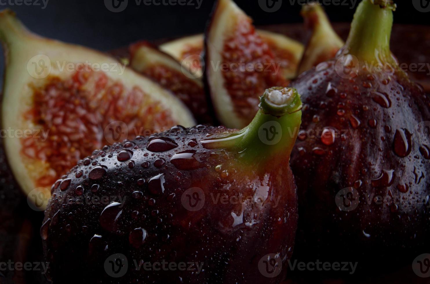 Figs are whole and cut into pieces. ripe figs with water drops on the peel. photo