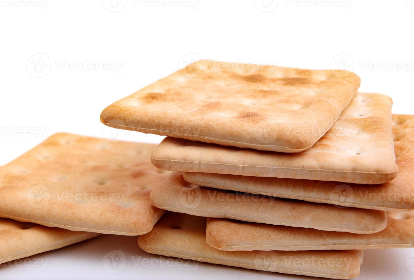 una pila de galletas crujientes cuadradas sobre un fondo blanco. foto