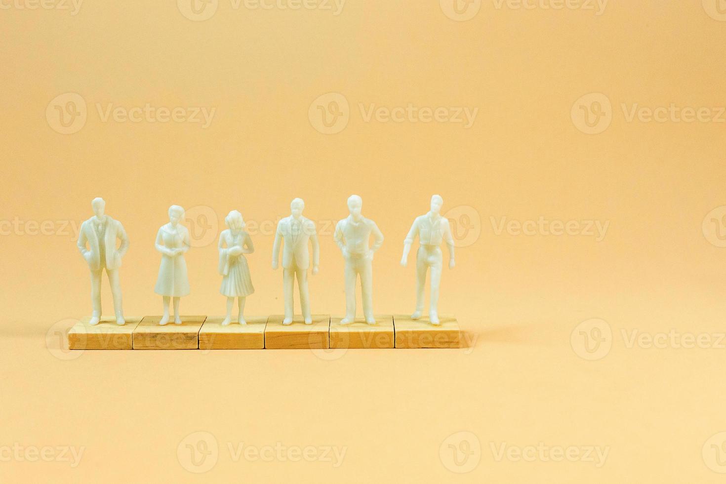 white  figure miniature on orange pastel for business content. photo